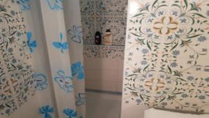 a bathroom with blue and white wallpaper and a mirror at Domino House Sorrento Center in Sorrento