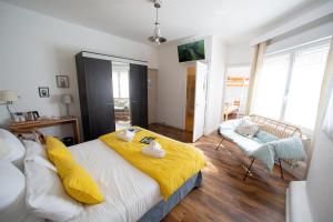 Un dormitorio con una cama con una manta amarilla. en Hôtel Le Vert Bois en Dolus d'Oléron