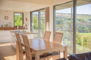 een keuken met een tafel en stoelen en een groot raam bij Sea Loch View Holiday Home in Portree