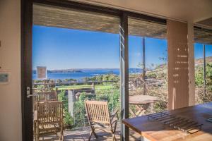 a room with a large glass door with a table and chairs at Sea Loch View Holiday Home in Portree