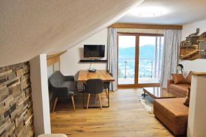 Alpengasthof Krische في موراو: غرفة معيشة مع طاولة وأريكة