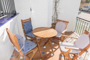 d'une table et de quatre chaises sur un balcon. dans l'établissement Apartamento Alextia La Barrosa, à Chiclana de la Frontera
