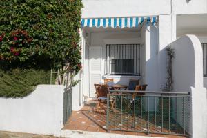 - une terrasse couverte avec une table et des chaises dans une maison dans l'établissement Apartamento Alextia La Barrosa, à Chiclana de la Frontera