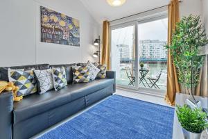 a living room with a blue couch and a large window at On the Water with Free Parking - By My Getaways in Brighton & Hove