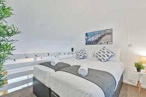 a white bedroom with a large bed with pillows at On the Water with Free Parking - By My Getaways in Brighton & Hove