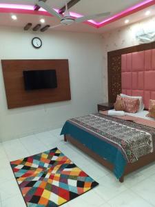 a bedroom with a bed and a tv and a rug at Kingston Motel in Karachi