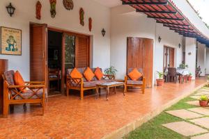 a porch of a house with chairs and a couch at StayVista at Firefly Homestay with Pvt Pool & Terrace Access in Bangalore