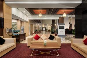 a lobby with a couch and a coffee table at Ramada by Wyndham Islamabad in Islamabad