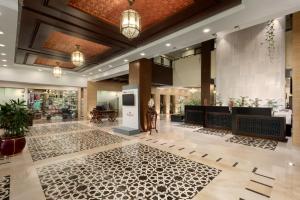 un vestíbulo de un hotel con una mujer de pie en el vestíbulo en Ramada by Wyndham Islamabad en Islamabad