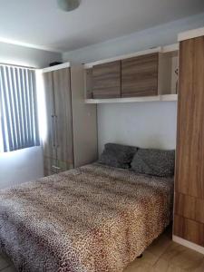 1 dormitorio con cama, armarios y ventana en Apartamento na Praia, en Ilhéus