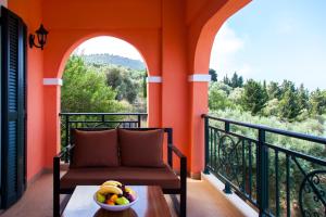 a balcony with a chair and a bowl of fruit on a table at Villa Anna in Athani