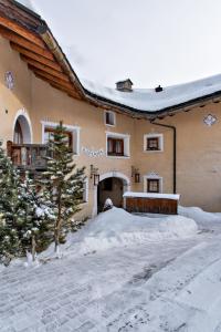 a house in the snow with a christmas tree at Chesa Romana - Silvaplana in Silvaplana