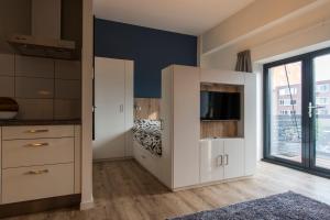 1 dormitorio con armarios blancos, 1 cama y ventana en JOINN! City Lofts Houten Utrecht en Houten