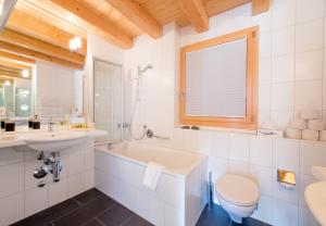 a white bathroom with a sink and a toilet at Chalet Wyssbirg in Wengen +31 photos