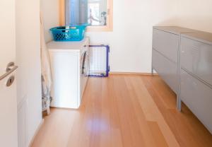 a kitchen with white cabinets and a wooden floor at Chalet Wyssbirg in Wengen