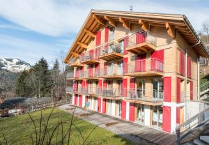 a building with red balconies on the side of it at Chalet Wyssbirg in Wengen
