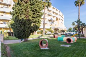 een park met kleurrijke speeltoestellen voor een gebouw bij IM On Meia Praia Terrasse in Lagos