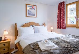 a bedroom with a large white bed with towels on it at Panoramapark Soleil Chalet C in Wengen