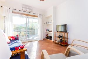 een woonkamer met een bank en een tv bij IM On Meia Praia Terrasse in Lagos