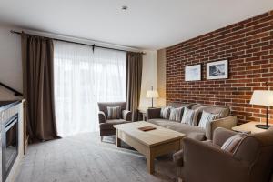 un soggiorno con divano, sedie e muro di mattoni di AmstelSki a Bukovel