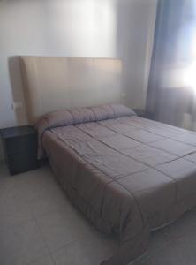 a bedroom with a large bed with a white bedspread at ESTUPENDO Apt.6 pax, TABLERO 10, cerca PLAYA INGLÉS in El Tablero