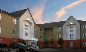 un gran edificio con coches estacionados en un estacionamiento en Candlewood Suites Richmond - South, an IHG Hotel, en Richmond