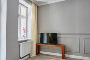 sala de estar con TV y mesa en Beżowy Apartament DE LUX dla 4 osób Chorzów Katowice, en Chorzów