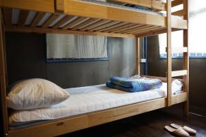 a bunk bed with pillows on the bottom bunk at Pickbaan in Lamphun
