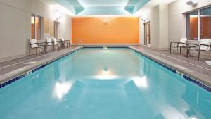 una gran piscina con sillas en un edificio en Candlewood Suites Kearney, an IHG Hotel, en Kearney