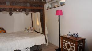 a bedroom with a bed and a pink lamp at Ambiance in Zierikzee