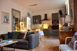 een woonkamer met een bank en een keuken bij calme et charme in Avignon