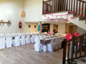un salón de banquetes con mesas blancas y sillas blancas en O Cruceiro, en Boiro