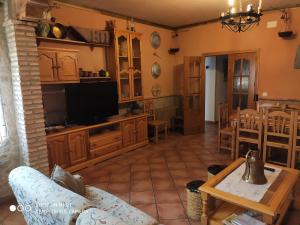 - un salon avec une télévision et une table dans l'établissement Casa Rural IRIS, à Villanueva de los Infantes