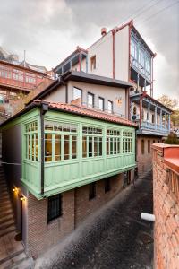 a building with a green facade on a street at Boutique Apart Upe in Tbilisi City