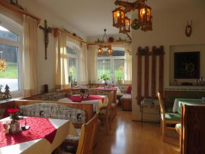 Garni Haus Jagerwirt في فوشل ام سي: غرفة طعام مع طاولات وكراسي ونوافذ