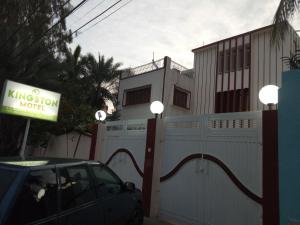 een auto geparkeerd voor een huis met een hek bij Kingston Motel in Karachi
