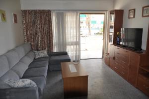 uma sala de estar com um sofá e uma televisão em BENIDORM LEVANTE BEACH VIEWS em Benidorm