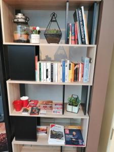 a book shelf filled with books and magazines at Mister Bed Chambray Les Tours in Chambray-lès-Tours