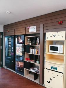 a room with a book shelf and a microwave at Mister Bed Chambray Les Tours in Chambray-lès-Tours