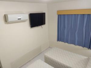a small room with a tv and a window at Patriarca Hotel in Itapeva