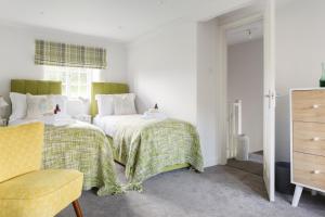 une chambre avec deux lits et une chaise dans l'établissement Carr Cottage, à Leeds