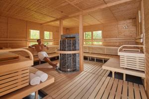 a man sitting in the middle of a sauna at ROBINSON NOONU - All Inclusive in Manadhoo