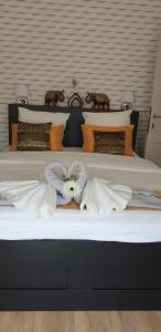 1 dormitorio con 2 camas con almohadas blancas y naranjas en BAAN SIAM en Bruges
