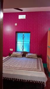 1 dormitorio con 1 cama grande y pared de color rosa en Vamoose Mangrove Pitta, en Kendrāparha
