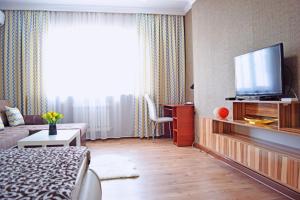 a living room with a television and a couch at Bishkek Sunny Apartment in the center in Bishkek