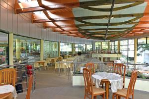 un restaurante con mesas, sillas y ventanas en Hotel Magnolia, en Albena