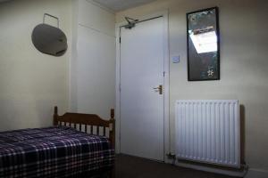 a bedroom with a door and a bed and a window at Leith City Centre Guesthouse Apartment in Edinburgh