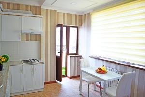a kitchen with a white table and a table and chairs at Bishkek Sunny Apartment in the center in Bishkek