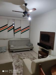 sala de estar con sofá y ventilador de techo en Casa Gomes, en Praia Grande