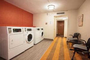 a laundry room with washing machines and chairs at Holiday Inn Downtown Rochester, an IHG Hotel in Rochester